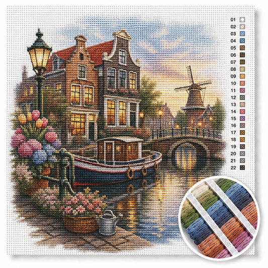 Avondsfeer aan de Amsterdamse gracht kruissteek pakket — grachtenpanden met verlichte ramen, woonboot en molen bij zonsondergang