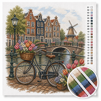 Hollandse fiets met tulpenmandjes kruissteek pakket — zwarte omafiets met tulpen op brug bij grachtenpanden en molen
