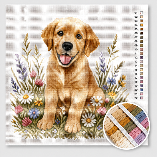 Labradorpup kruissteek pakket — vrolijke blonde labrador tussen wilde bloemen, lavendel en madeliefjes